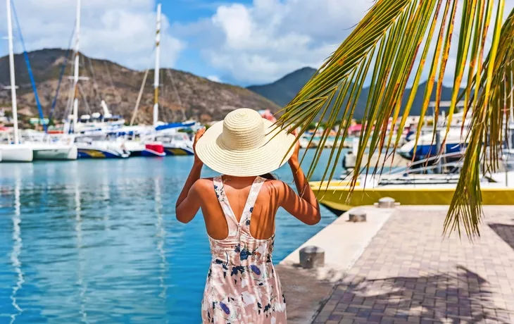 Junge Frau mit Sonnenhut im Philipsburg-Jachthafen beherbergten, St. Maarten, populärer Anlaufhafen für Kreuzschiffreisebestimmungsort. Niederländische Antillen, tropische Sommerferien.