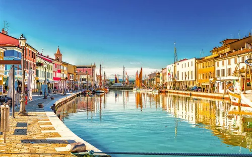 Bunte Häuser und Boote an einem sonnigen Kanal.