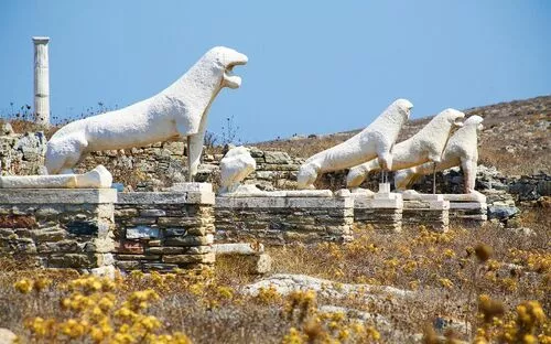 Steinlöwen-Statuen auf einer antiken Terrasse mit Blumen und Säule im Hintergrund