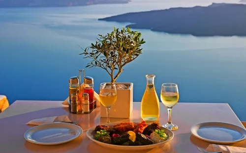 Tisch mit Essen und Getränken, Ausblick auf das Meer im Hintergrund