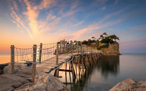 Holzsteg zur Insel Cameo vor Zakynthos in Griechenland im Ionischen Meer bei Sonnenuntergang.