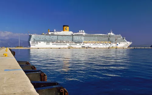 Kreuzfahrtschiff am Pier im Hafen unter blauem Himmel.