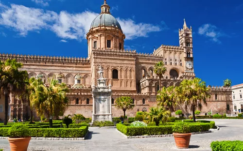 Kathedrale von Palermo mit Gärten und blauen Himmel im Hintergrund.