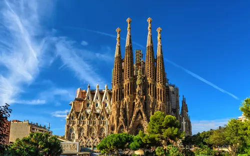 Sagrada Família bei klarem Himmel, umgeben von Bäumen.