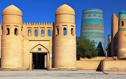 Historische Architektur mit Ziegelmauern und blauen Kuppeln unter blauem Himmel.