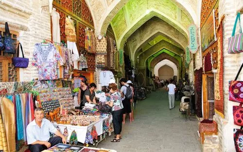 Menschen kaufen in einem traditionellen Basar mit Gewölbedecken in Buchara, Usbekistan ein.