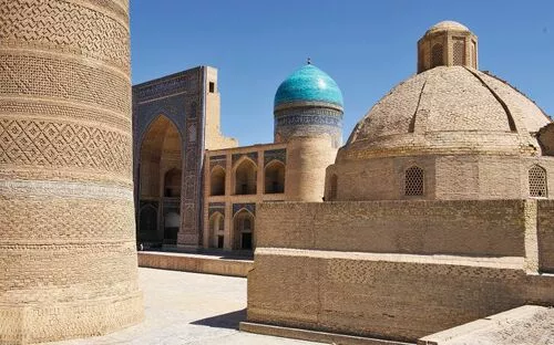 Gebäude der Medrese Miri Arab mit blauer Kuppel in Buchara, Usbekistan bei klarem Himmel.