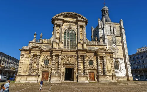 Barockkirche mit reich verzierter Fassade und Turm, blauer Himmel.