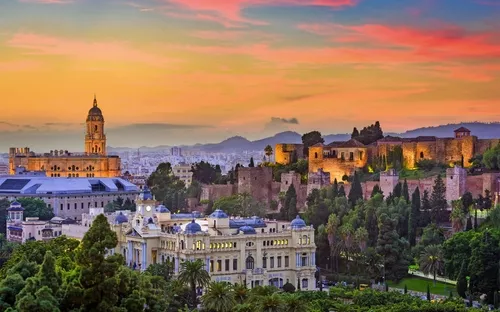 Panorama von Málaga mit Alcazaba und Kathedrale bei Sonnenuntergang.