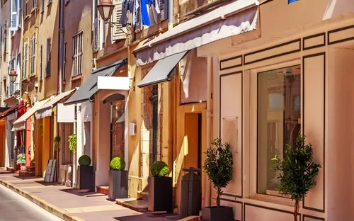 Schmale Straße mit alten, charmanten Gebäuden und Geschäften in Südeuropa.