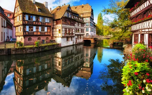 Fachwerkhäuser an einem Kanal in einer malerischen Altstadt mit Herbstlaub.