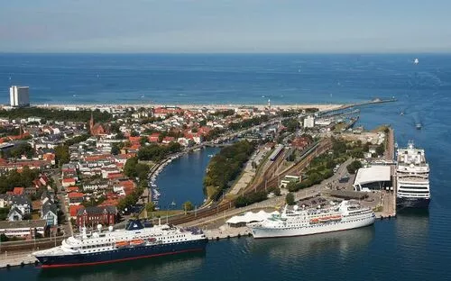 Panoramablick auf den Warnemünder Hafen mit Kreuzfahrtschiffen und Stadtansicht.