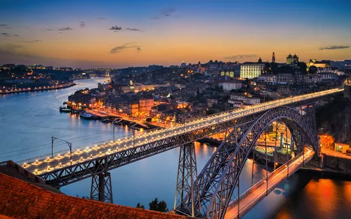 Brücke bei Sonnenuntergang über einem Fluss in einer Stadt.