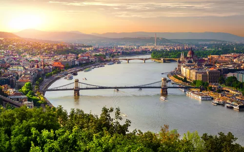 Panoramablick auf Budapest mit der Donau und Brücken im Sonnenuntergang.