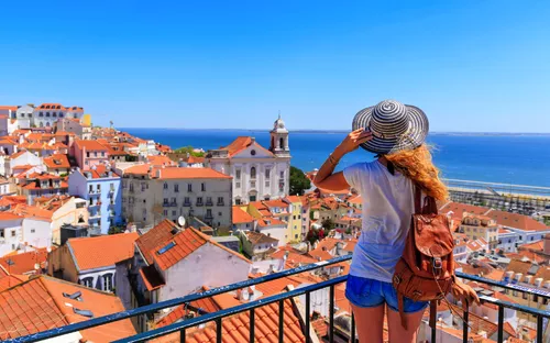 Touristin genießt die Aussicht auf die Altstadt von Lissabon und das Meer im Hintergrund.
