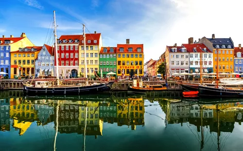 Nyhavn in Kopenhagen mit bunten Häusern und Schiffen im Hafen.