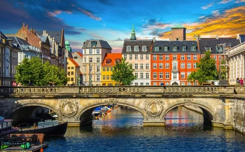 Brücke in Kopenhagen bei Dämmerung mit bunten Gebäuden im Hintergrund.