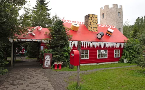 Lebkuchenhaus mit rotem Dach und Süßigkeiten darauf im Wald.