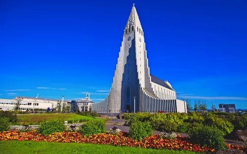Eine moderne Kirche mit markanter, hoher Fassade vor blauem Himmel.