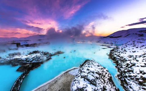 Heiße Quelle in verschneiter Landschaft bei Sonnenaufgang mit dampfendem Wasser.
