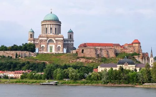 Große Basilika auf Hügel am Fluss mit angrenzenden alten Gebäuden.