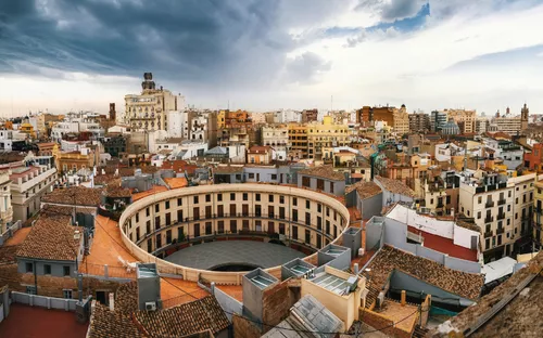 Panorama von Valencia mit Plaza Redonda im Vordergrund, bewölkter Himmel im Hintergrund.