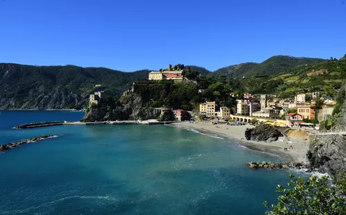 Küstenstadt mit Strand und bunten Häusern an einem sonnigen Tag.