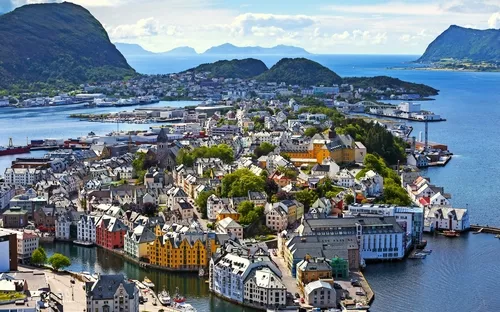 Panorama der Stadt Ålesund in Norwegen mit bunten Häusern und Wasser im Hintergrund.