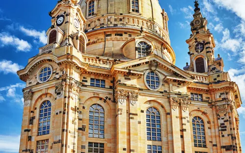 Eine barocke Kirche mit großer Kuppel und reich verzierten Fassaden unter einem blauen Himmel.