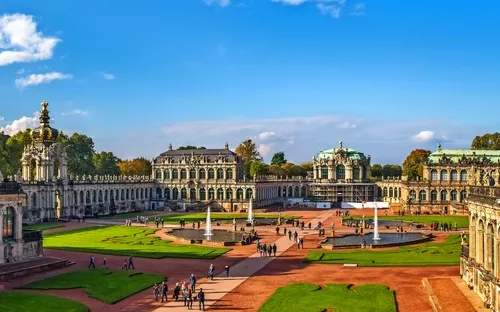 Barocke Architektur des Dresdner Zwingers bei sonnigem Wetter, Menschen auf dem Platz.