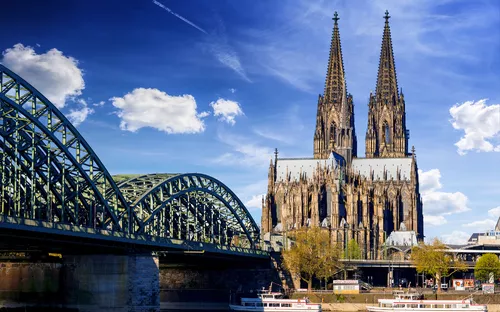 Kölner Dom und Hohenzollernbrücke bei sonnigem Wetter.
