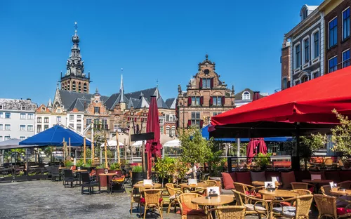 Stadtplatz mit Cafés und historischen Gebäuden unter klarem Himmel