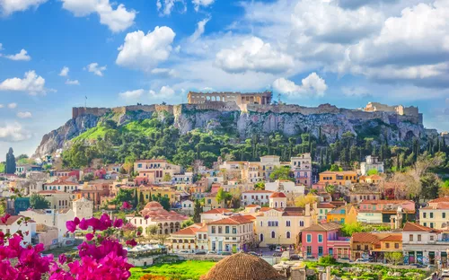 Aussicht auf Athen mit Akropolis und blühenden Bäumen im Vordergrund.