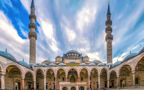 Historische Moschee mit zwei Minaretten und blauem Himmel im Hintergrund.
