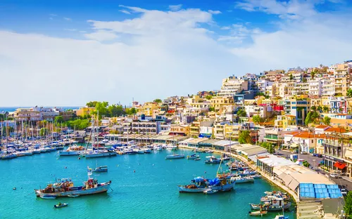 Marina in Piräus, Griechenland mit zahlreichen Booten und Häusern am Hang.