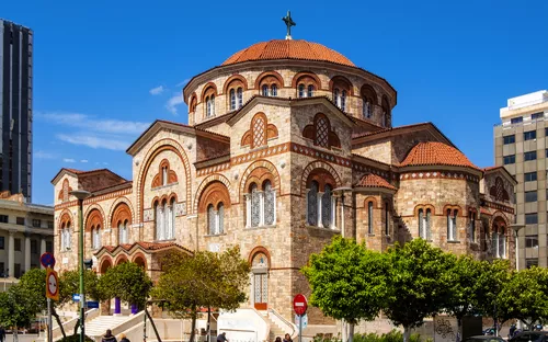 Kirche mit runder Kuppel und Steinmauerwerk vor blauem Himmel.