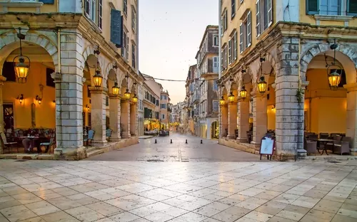 Historische Gasse mit Arkaden und Laternen in einer europäischen Stadt.