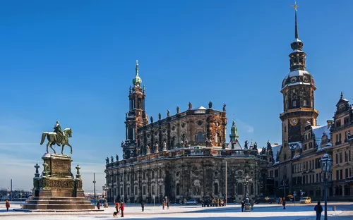Schneebedeckter Platz in Dresden mit Hofkirche und Reiterstatue im Winter.
