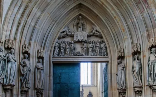 Steinerne Kirchentür mit gotischen Skulpturen und Reliefs.