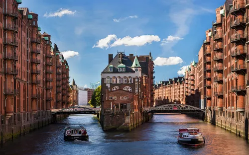 Backsteingebäude und Boote in Speicherstadt, Hamburg bei Tag.