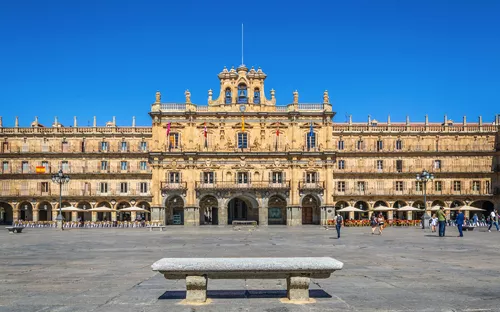 Historisches Gebäude an einem öffentlichen Platz mit blauem Himmel.