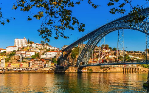 Brücke über Fluss mit Stadtansicht im Hintergrund.