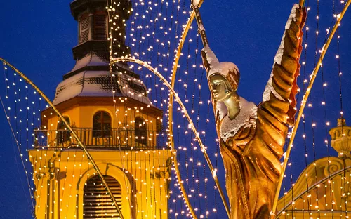Beleuchtete Engelsfigur und Kirchturm auf dem Ludwigsburger Barock-Weihnachtsmarkt.
