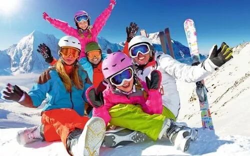 Familie beim Wintersport im Schnee, lachende Skifahrer haben Spaß zusammen in den Bergen.