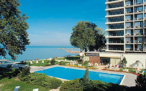Hotelgebäude am Ufer mit Pool und Blick auf den See.