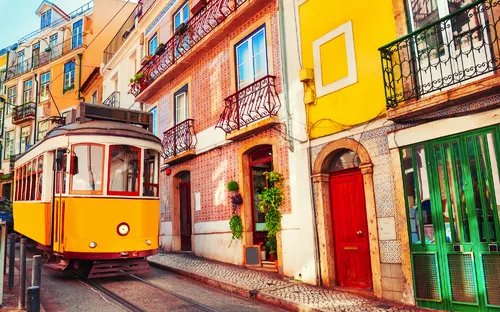 Straßenbahn Ascensor da Bica in der Altstadt von Lissabon, Portugal, umgeben von bunten Gebäuden.