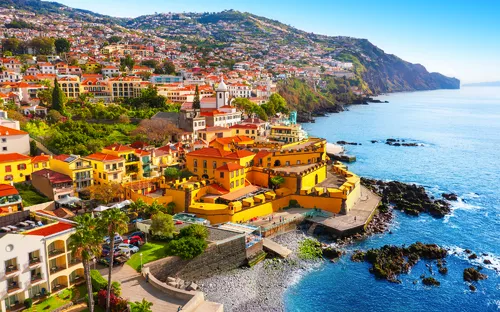 Küstenstadt mit bunten Gebäuden und Meerblick.