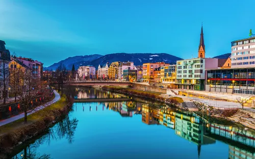 Stadtansicht bei Abenddämmerung mit Fluss und Kirche im Hintergrund