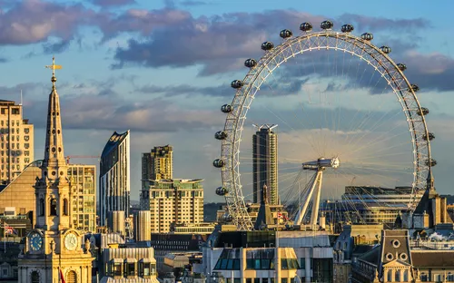 Stadtansicht mit London Eye und umliegenden Gebäuden bei Sonnenuntergang.