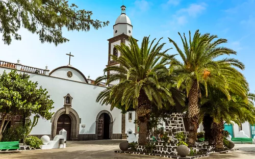 Plaza de las Palmas in Arrecife auf Lanzarote mit Kirchengebäude und Palmen im Vordergrund.